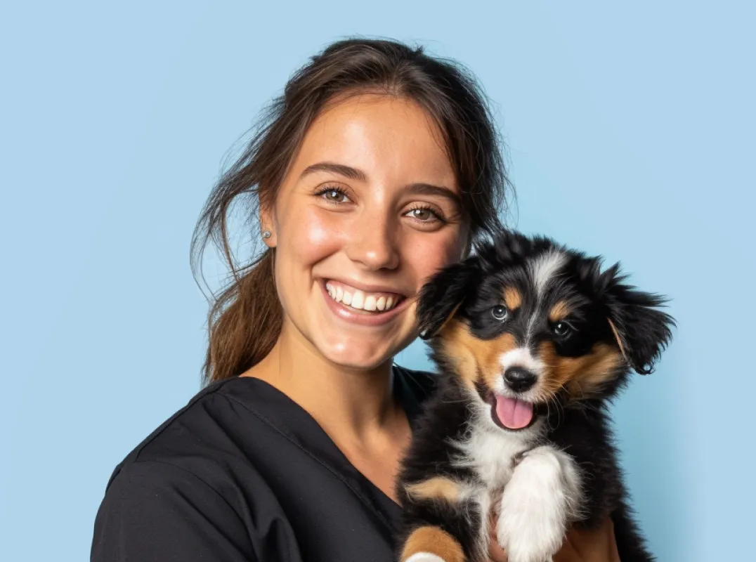 A smiling woman holding a puppy